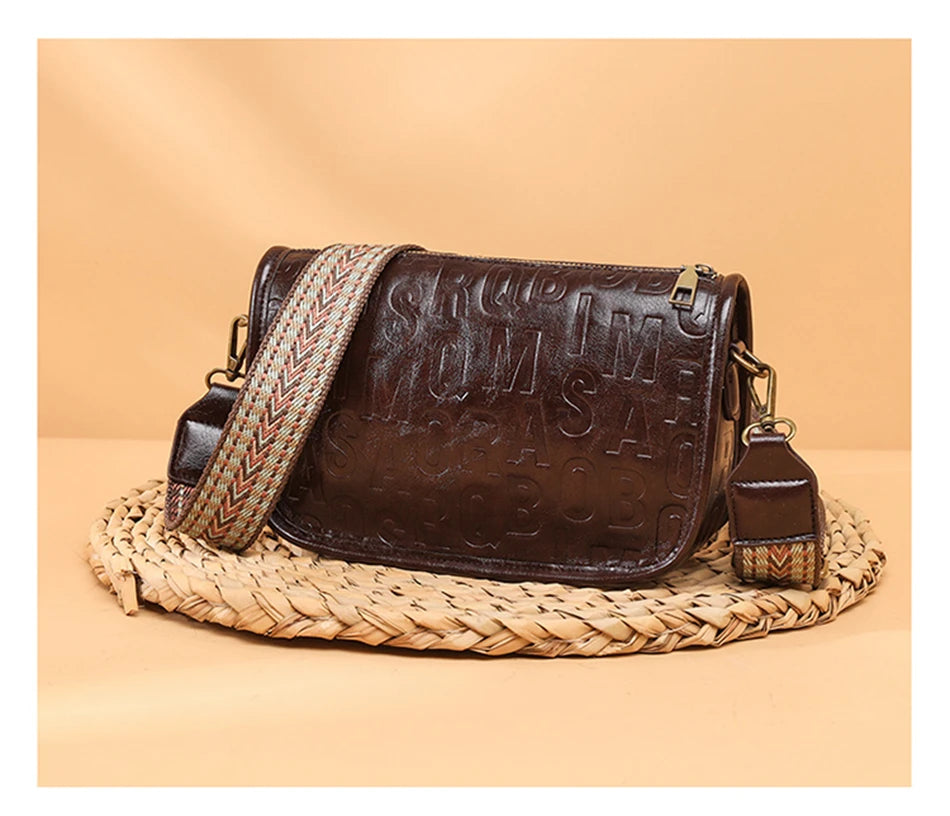 Sac à bandoulière vintage pour femme en cuir embossé marron claire, avec sangle tressée beige et rouge.