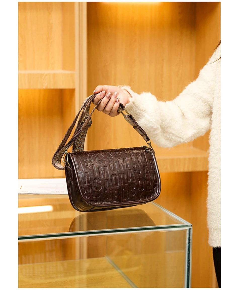 Sac à bandoulière vintage pour femme en cuir embossé marron, avec sangle tressée beige et rouge.