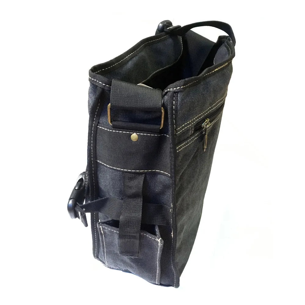 Vue latérale d’un sac bandoulière homme bleu en toile épaisse, avec poches extérieures, surpiqûres blanches apparentes et fermeture éclair zippée.