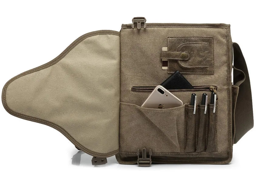 Intérieur du sac bandoulière homme en toile marron, avec poches organisatrices contenant un smartphone, un carnet et des stylos. Rabat ouvert dévoilant le compartiment de rangement fonctionnel.