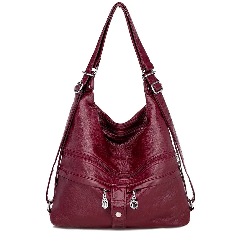 Sac à main en cuir bordeaux de la marque Vanderwah, vu de face, avec double fermeture éclair et bouton pression décoratif.