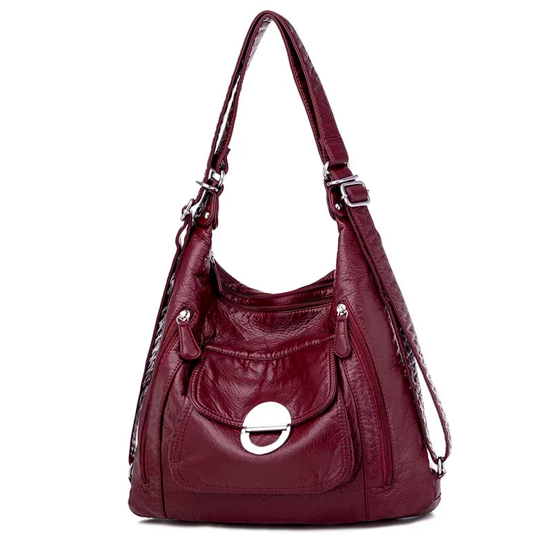 Sac à main en cuir bordeaux de la marque Vanderwah, vu de face, avec une poche avant ornée d’une fermeture ronde métallique.