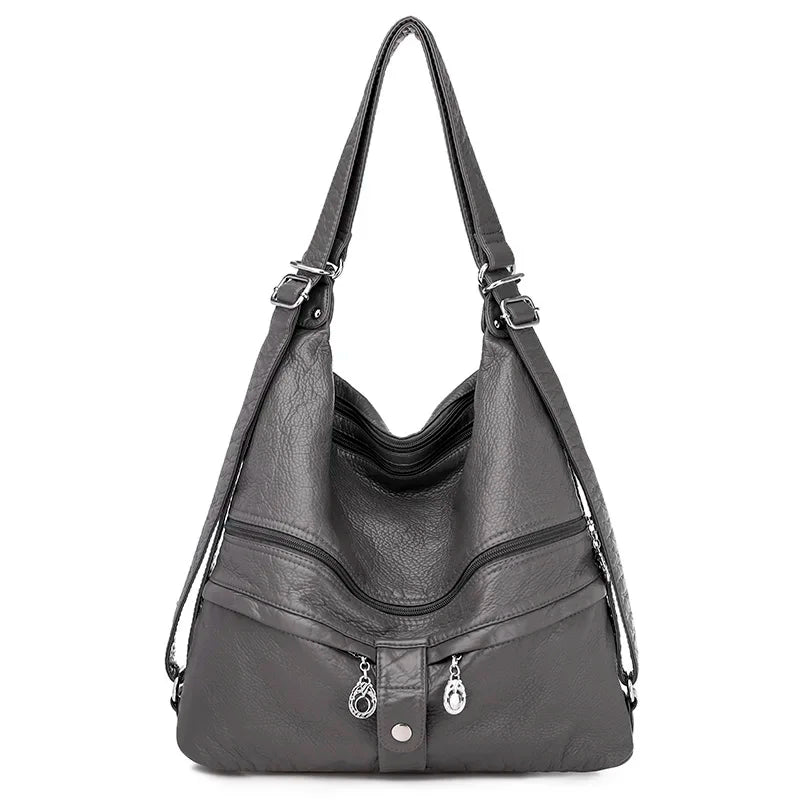 Sac à main en cuir gris de la marque Vanderwah, vu de face, avec double fermeture éclair et bouton pression décoratif.