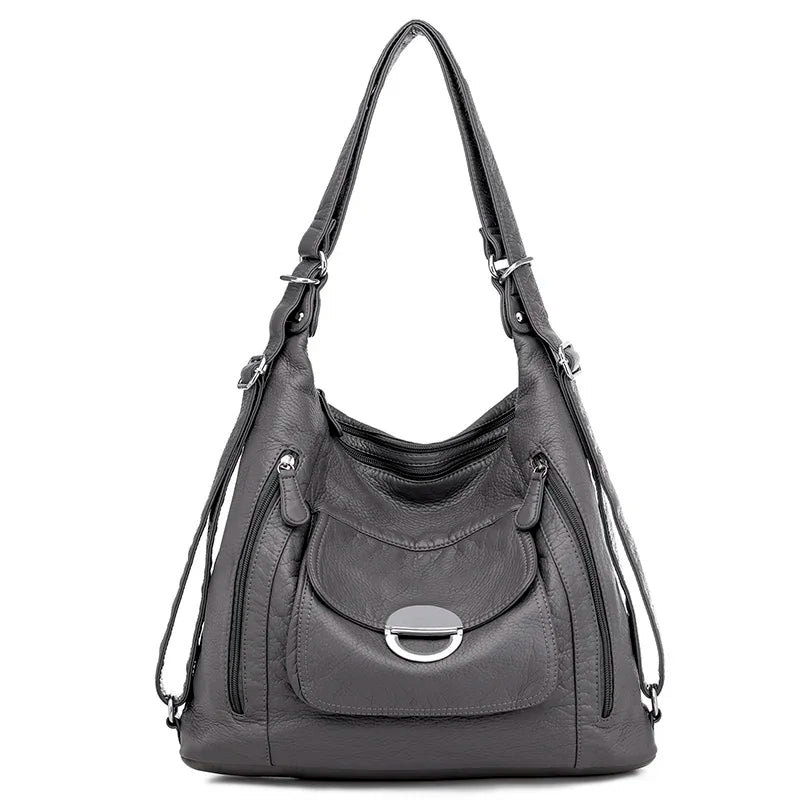 Sac à main en cuir gris de la marque Vanderwah, vu de face, avec une poche avant fermée par un élégant disque métallique.