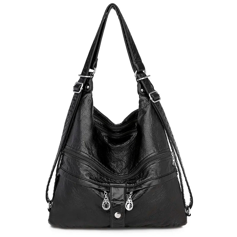 Sac à main en cuir noir de la marque Vanderwah, vu de face, avec double fermeture éclair et bouton pression décoratif.