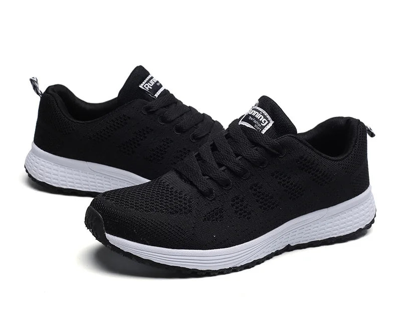 Paire de baskets noires respirantes pour femme, semelle blanche antidérapante, idéale pour le sport ou les balades.