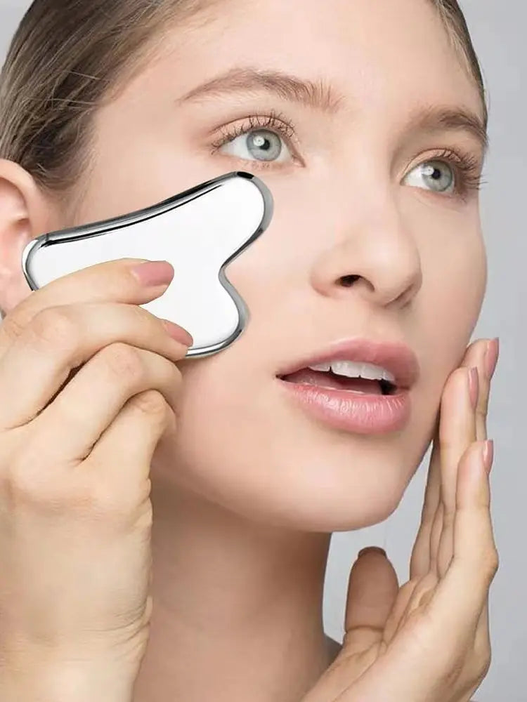Femme utilisant un Gua Sha en obsidienne noire pour masser son visage