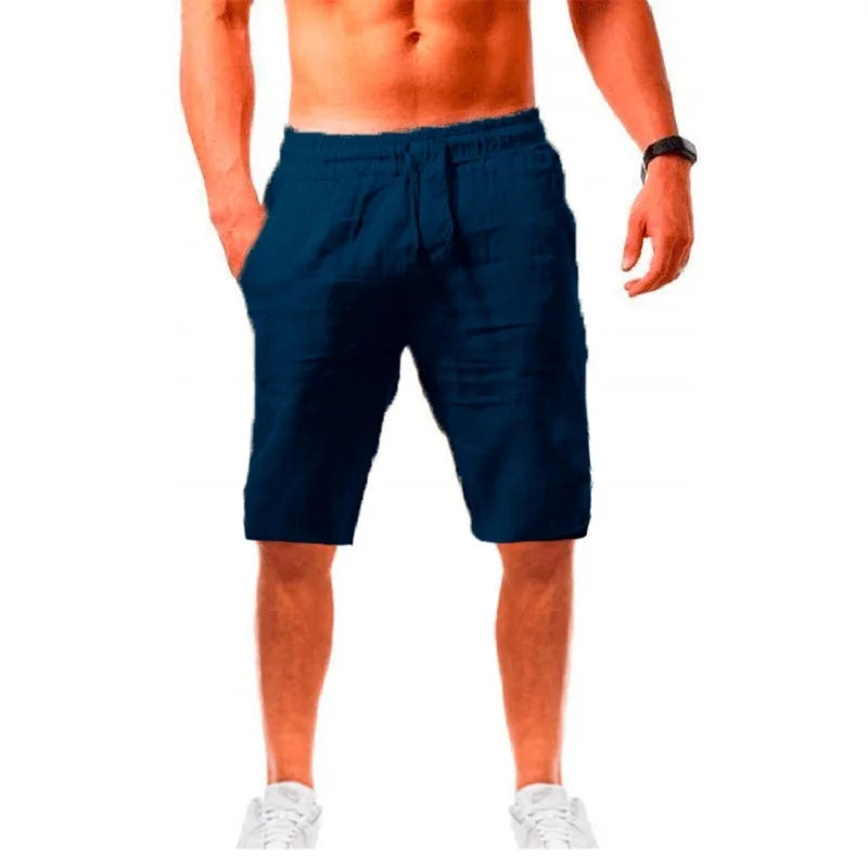 Homme élégant portant un short bleu marine en lin ALTAREV, marchant près de la mer sur des escaliers blancs, ambiance estivale chic.