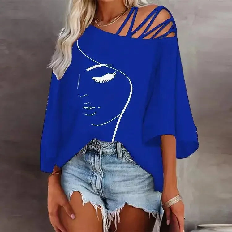 "Femme portant un t-shirt bleu électrique à col asymétrique, imprimé visage blanc, coupe ample avec manches courtes et bretelles croisées."