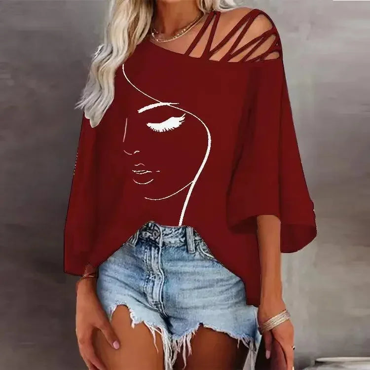 "Femme portant un t-shirt rouge à col asymétrique, imprimé visage artistique blanc, coupe ample avec manches courtes et bretelles croisées."