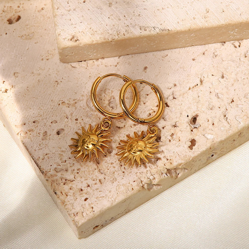 Boucles d’oreilles créoles dorées 18K posées sur fond pierre – ALTAREV