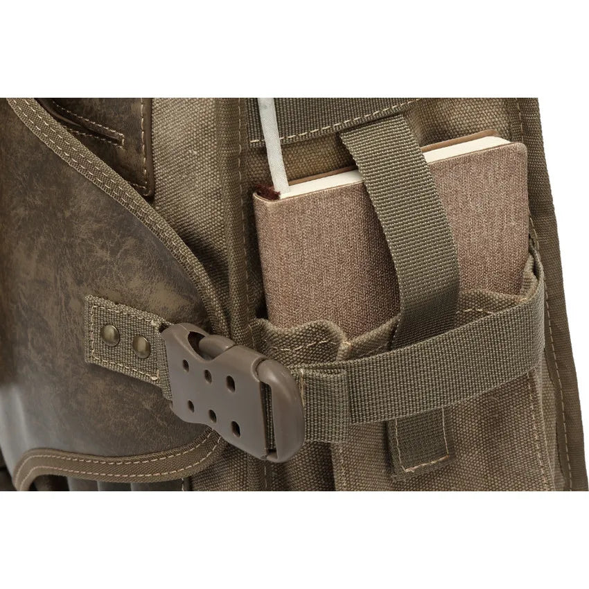 Poche latérale du sac bandoulière en toile contenant un carnet rigide, avec sangle de maintien et boucle robuste – vue en gros plan.