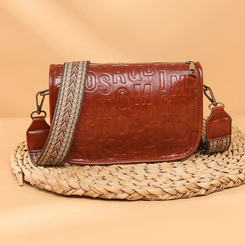 Sac à bandoulière vintage pour femme en cuir embossé rouge, avec sangle tressée beige et rouge.
