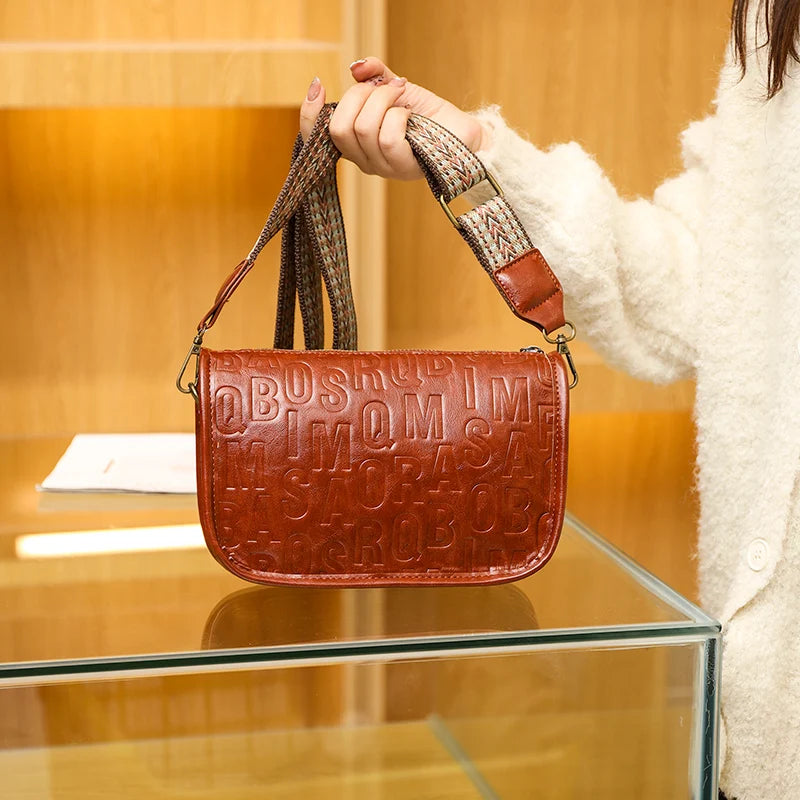 Sac à bandoulière vintage pour femme en cuir embossé rouge, avec sangle tressée beige et rouge.