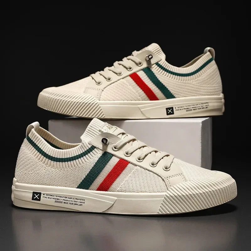 Sneakers homme beige portées avec jean retroussé, design en maille avec bandes verte et rouge, look urbain et décontracté.