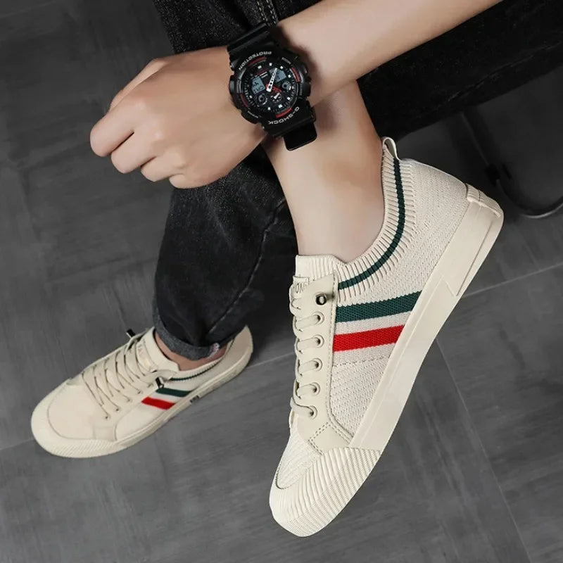 Sneakers homme beige portées avec jean retroussé, design en maille avec bandes verte et rouge, look urbain et décontracté.