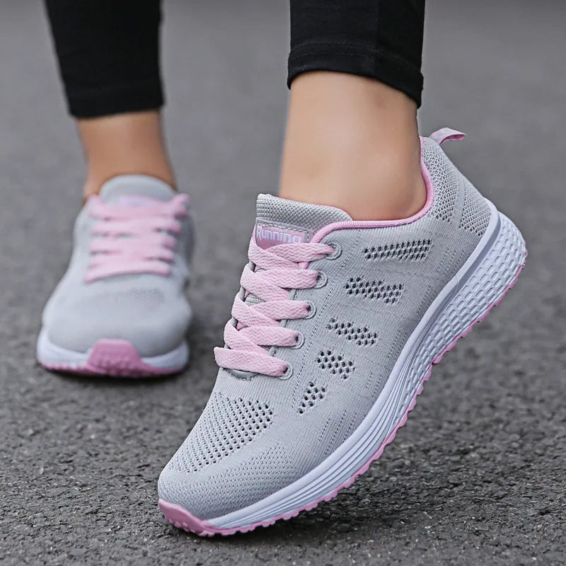 Baskets femme grises avec lacets roses, semelle légère et amortissante, parfaites pour le sport, la marche ou un style décontracté.