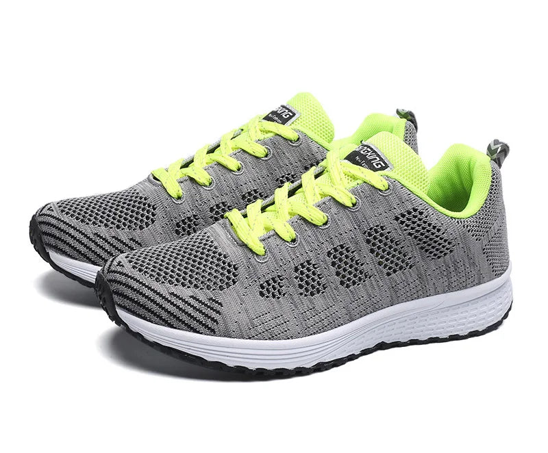 Paire de baskets grises avec lacets et doublure jaune fluo, semelle blanche et noire, parfaites pour la course à pied ou un look urbain.

