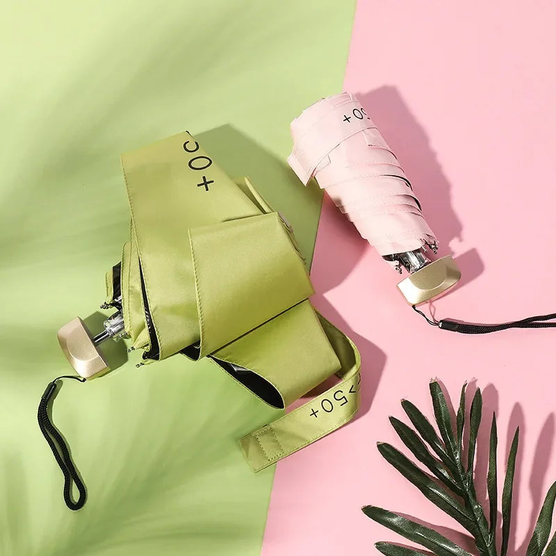 Parapluies pliables rose pastel et vert citron avec protection solaire UPF50+, design compact et élégant.

