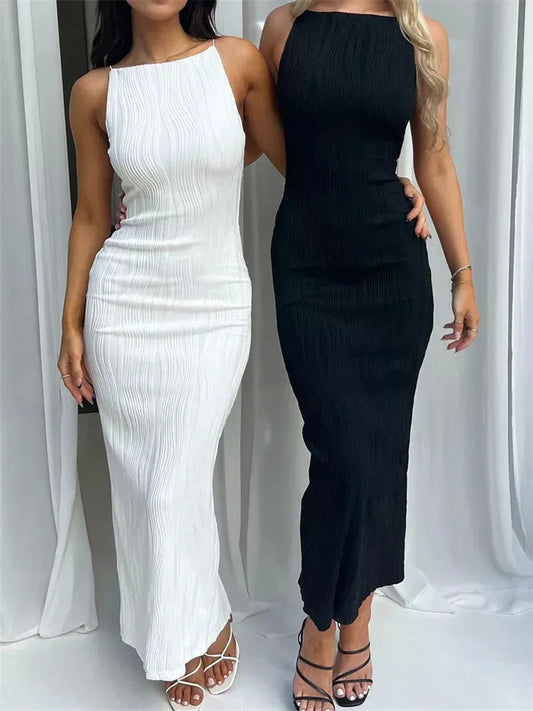 Deux femmes portant une robe longue ALTAREV, sans manches, dos nu, l'une en blanc et l'autre en noir, dans un décor épuré.