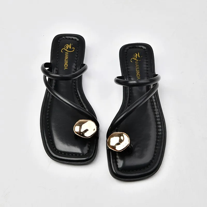 Sandales noires ouvertes pour femme avec bijou doré sur le devant – modèle élégant 