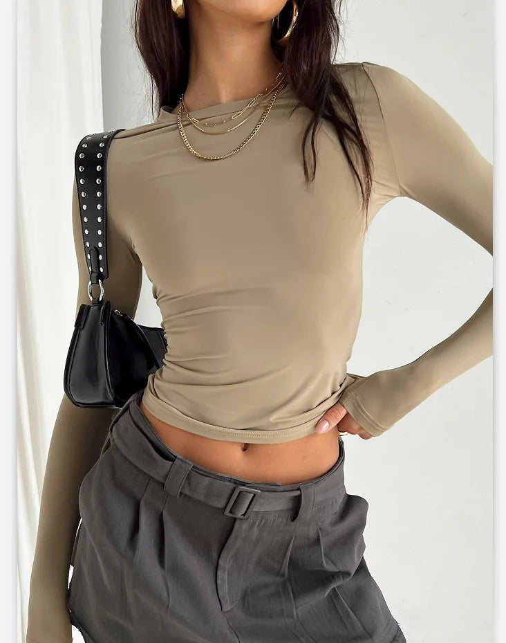 T-shirt femme beige manches longues, coupe ajustée, porté avec pantalon gris foncé – style élégant